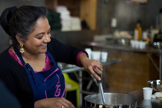 图为一名印度妇女在为手艺教授烹饪课