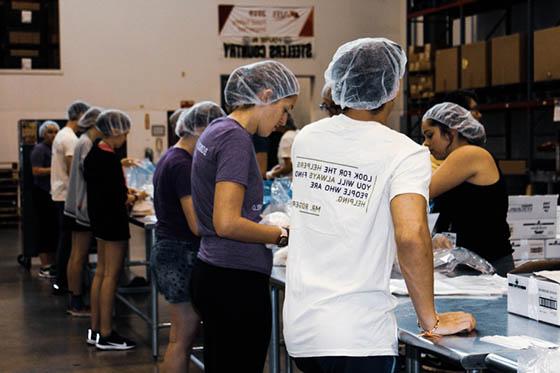 图为波胆网站的学生在食品银行做志愿者