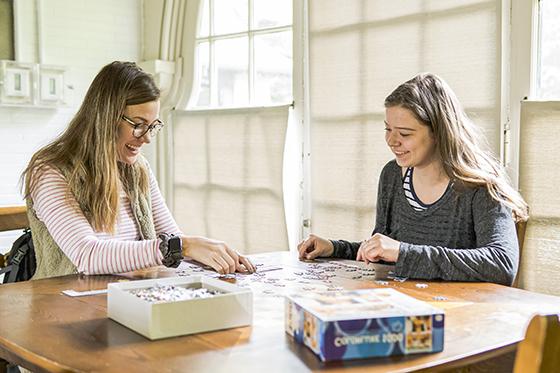 图为两名波胆网站的学生在休息室的桌子上玩拼图游戏